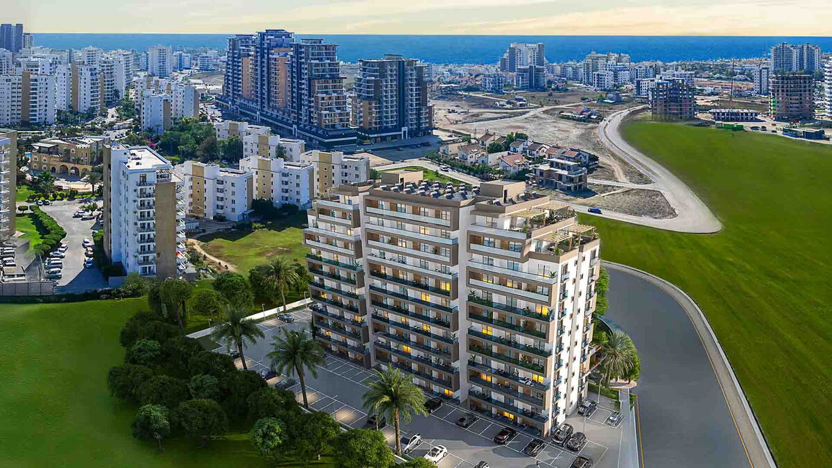Sea Breeze — Havadan apartman bloğu, çevresinde yeşil alan, arkada şehir ve deniz (görselleştirme)