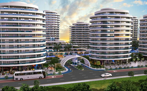 Ocean Life Residence — Gün batımında kuleler, yaya köprüsü ve önden geçen otobüslü cadde görselleştirmesi